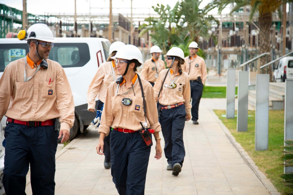 Operarios con cascos de seguridad caminando por el complejo