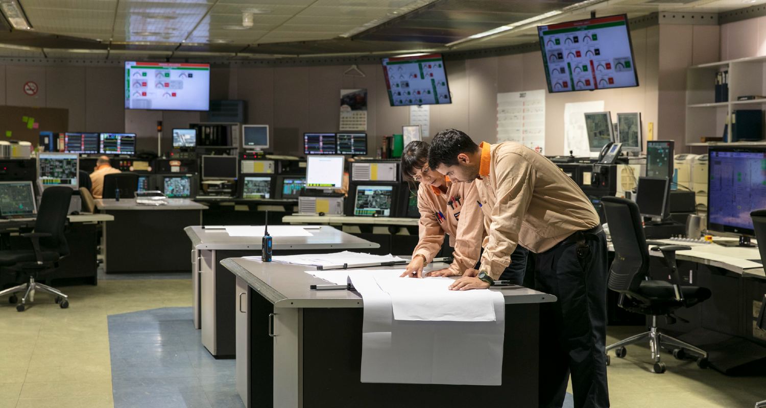 Dos empleados en una refinería mirando un mapa