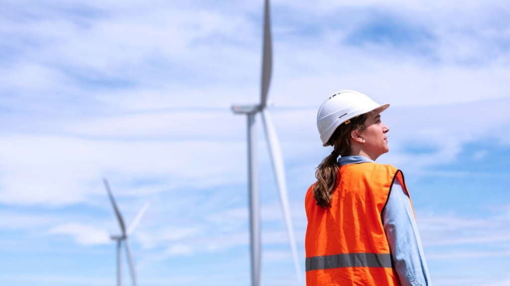 Operaria con casco y aerogenerador de fondo